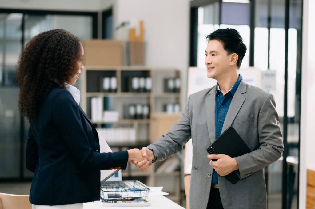 A sales professional shaking hands with his client after a meeting.